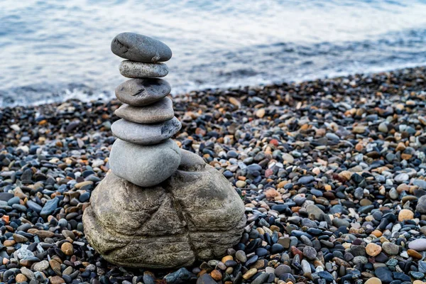 Stone tower of pebbles on sea shore — Stock Photo, Image