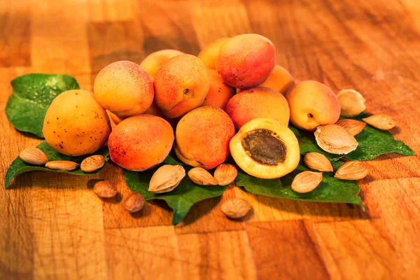 Свіжі абрикоси, листя і насіння на дерев'яній поверхні — стокове фото