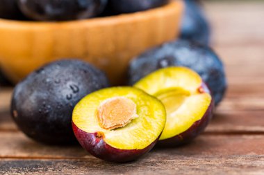 Yakın taze olgun erik ve yarım ahşap kase