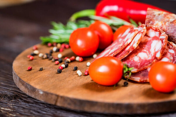 Tasty salami with tomatoes and peppercorn close