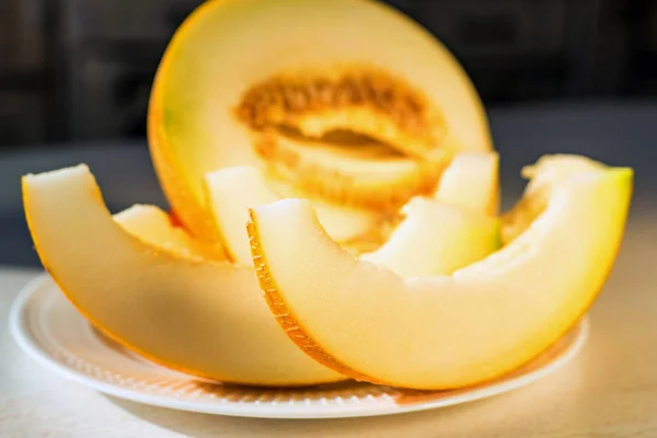Demi-melon et tranches de melon sur plaque blanche fermer — Photo