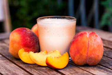 Şeftali yoğurt ve şeftali ahşap masa üzerinde cam