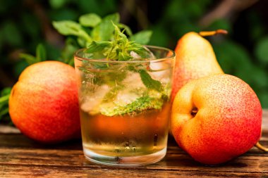 Olgun armut ve armut içki ahşap bir masa üzerinde