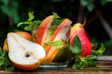 Olgun armut ve armut içki ahşap bir masa üzerinde