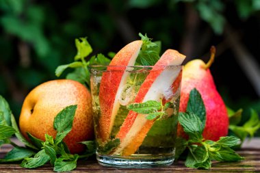 Olgun armut ve armut içki ahşap bir masa üzerinde