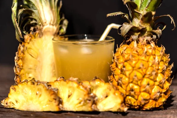 Pineapple juice and slice placed on a wooden table