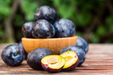 Yakın taze olgun erik ve yarım ahşap kase