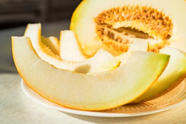 Demi-melon et tranches de melon sur plaque blanche fermer — Photo