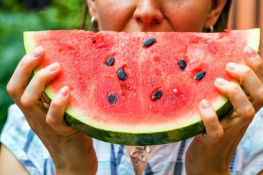 Kadın dilim taze karpuz yiyor