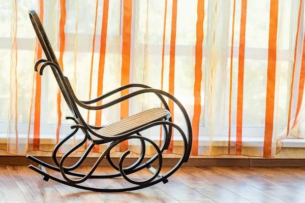 Singola sedia a dondolo in vimini marrone in sala — Foto Stock