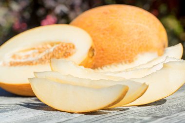 Ahşap masa açık havada tüm ve dilimlenmiş kavun