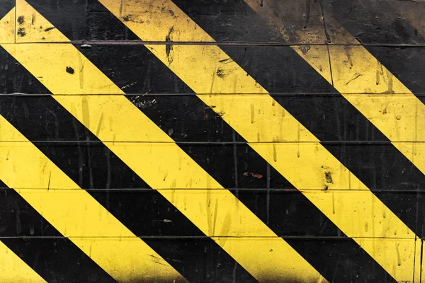 검은 선과 노란 선이 벽에 있습니다. 위험 신호 — 스톡 사진