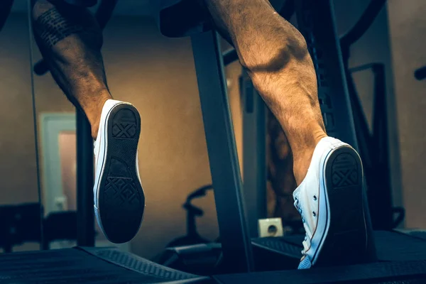 De benen van een man op de sportschool loopband — Stockfoto