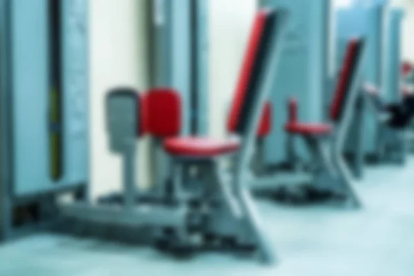 New fitness machines in modern gym interior blurred