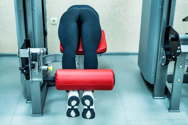 Young woman does leg exercises in gym lying — Stock Photo, Image