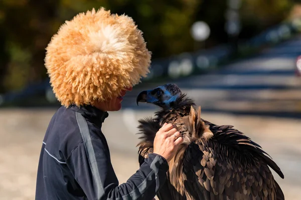 Owner talks to his Black vulture. Bird for tourist photos — Stock Photo, Image