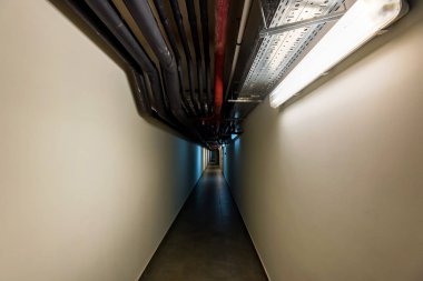 Tavanda birçok borularla sanayi sitesinde dar koridor