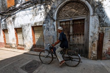 Stone Town, Zanzibar - 9 Ocak 2015: Tanımlanamayan cycler taş şehir sokak