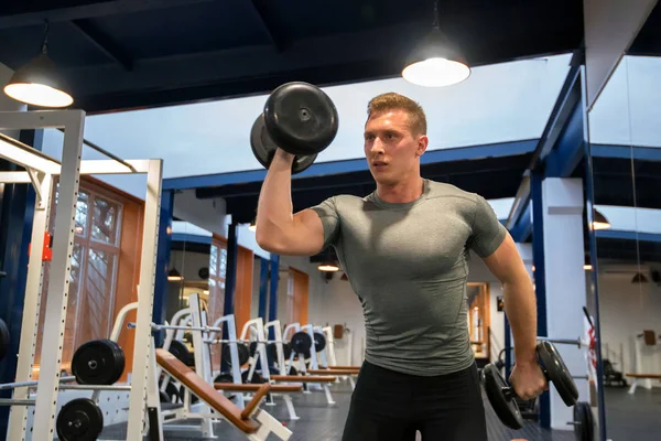Portrét mužské sportovce vlaky biceps v tělocvičně — Stock fotografie