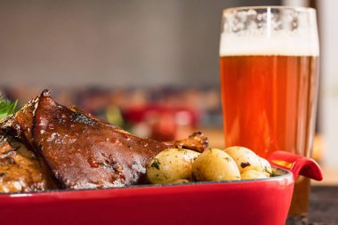 Haşlanmış patates ve bardak bira eşliğinde kızarmış domuz knuckle up kapatın