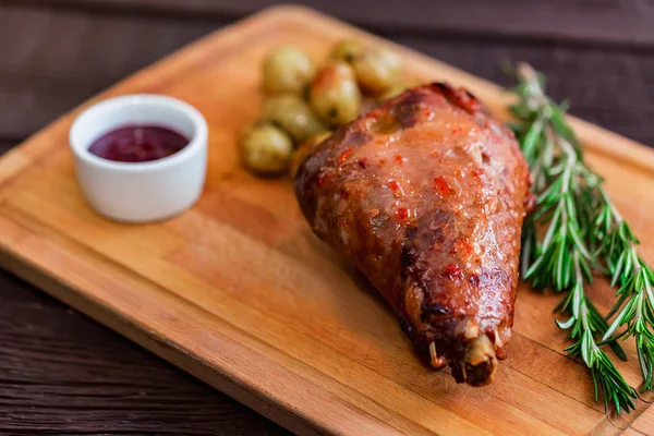 Close up roasted turkey filet with spices, vegetables and jam on wooden board