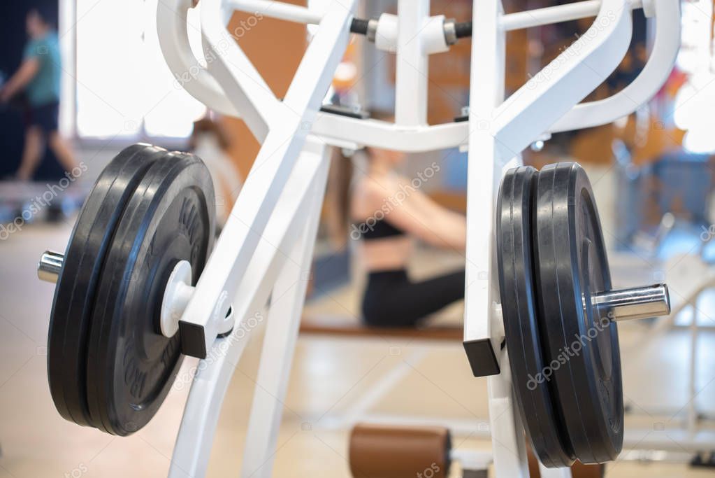 Fitness black weight plates on exercise machine in gym close