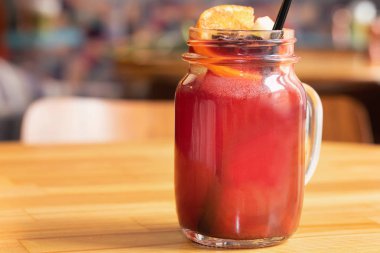 Cam sürahi sıcak mulled şarap ve saman hafif ahşap masa üzerinde kapatın