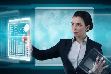 Genç iş kadını fütüristik ofiste sanal grafik arayüzü ile çalışıyor.