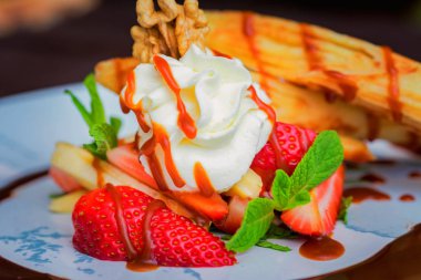 Lezzetli tatlı waffle ile yakından rulo, dondurma ve çilek