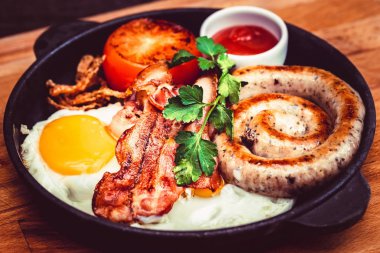 Sahanda yumurta, sosis, pastırma, domates, sos tava ile Besleyici yemek