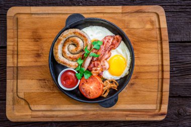 Üstten Görünüm yemek kızarmış yumurta, sosis, pastırma, domates, sos tava ile