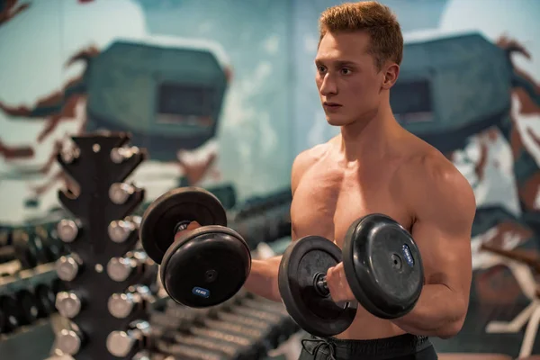 Atraktivní mužský atlet dělá biceps cvičení s činkami — Stock fotografie
