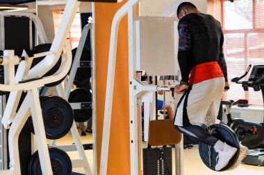 Genç kaslı adam modern spor salonunda egzersiz daldırma