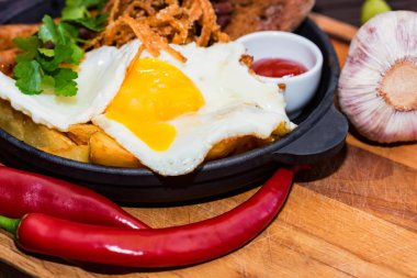 Kızarmış yumurta, sosis, fasulye, soğan halkaları, biber ve sos ile yemek