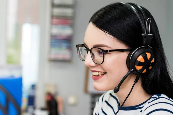 Young beautiful smiling girl with glasses and headphones — Stock Photo, Image