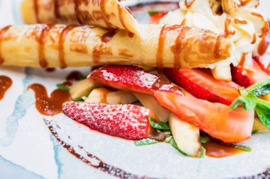 Lezzetli tatlı waffle ile yakından rulo, dondurma ve çilek