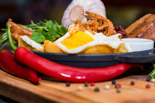 Kızarmış yumurta, sosis, fasulye, soğan halkaları, biber ve sos ile yemek