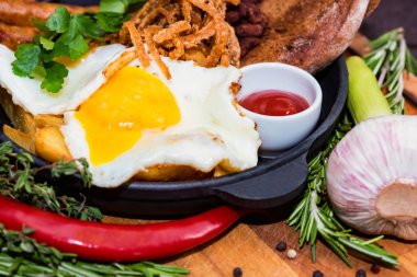 Kızarmış yumurta, soğan halkaları, biber ve sos kızartma tava ile yemek