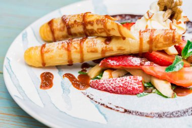 Lezzetli tatlı waffle ile yakından rulo, dondurma ve çilek