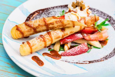 Lezzetli tatlı waffle ile yakından rulo, dondurma ve çilek