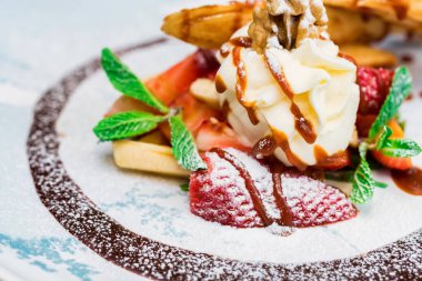 Lezzetli tatlı waffle ile yakından rulo, dondurma ve çilek