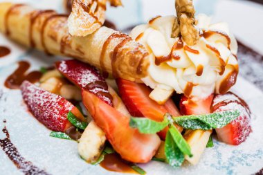 Lezzetli tatlı waffle ile yakından rulo, dondurma ve çilek