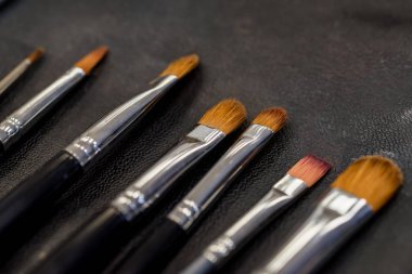 Karanlık yüzeyde yakın yatan makyaj fırçaları seti