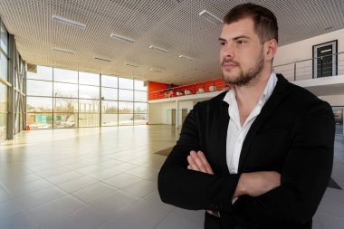 Boş bayi merkezi arka plan üzerinde güzel ciddi iş adamı