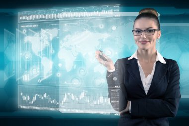 Genç iş kadını fütüristik ofiste sanal grafik arayüzü ile çalışıyor.