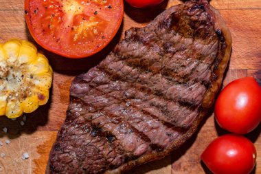 Domates ve mısır ile ahşap taze ızgara biftek kapatın