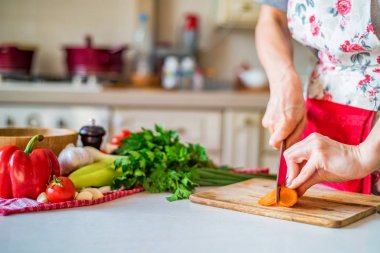 Bıçak ile kadın el mutfakta havuç keser. Pişirme sebzeler