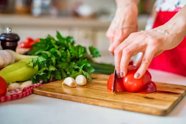 Female hand with knife slices bell pepper in kitchen. Cooking vegetables — Stock Photo, Image