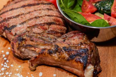 Kasede taze ızgara kemik biftek ve ahşap taze salata kapatın