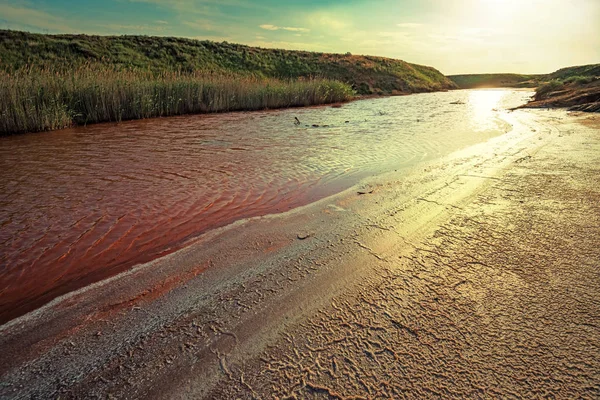 Vista de pequeno rio de água vermelha cheio de ferro na bela estepe — Fotografia de Stock